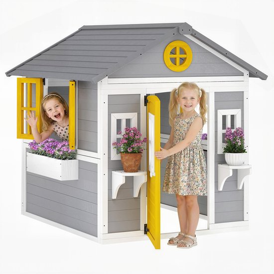 Twee meisjes bij een grijs speelhuis met gele deur en bloemen.