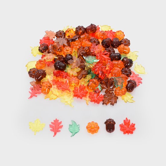 Pile de feuilles transparentes aux couleurs d'automne, citrouilles et glands de différentes tailles et teintes d'orange, rouge, marron et jaune.