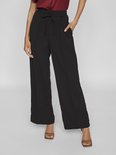 Model met zwarte wijde broek met trekkoord en bordeauxrode top. Broek heeft steekzakken.