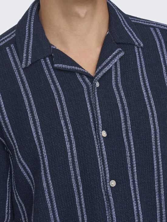 Detail van een donkerblauw gestreept overhemd met open kraag.