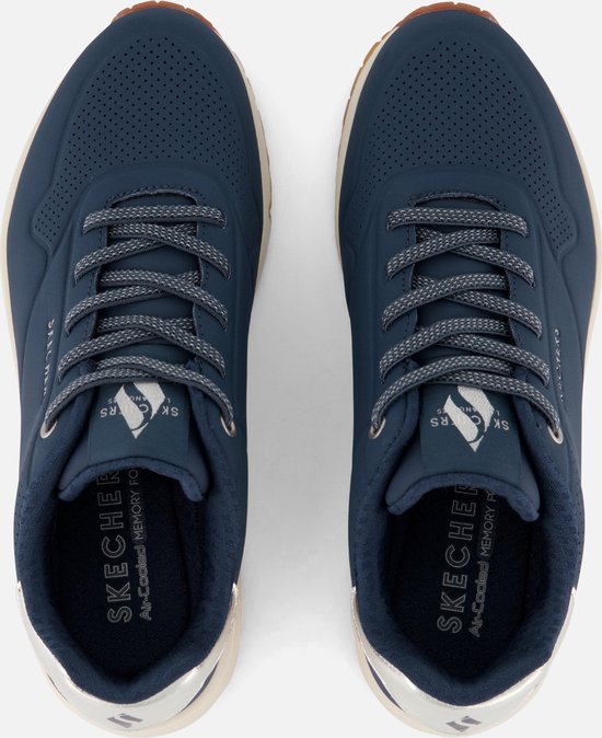 Bovenaanzicht van een paar Skechers sneakers, donkerblauw met zilverkleurige accenten op de hiel.