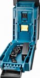 Open Makita bouwradio met turquoise compartiment voor accu en oplader, en meegeleverde oplader.