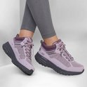 Een paar paarse Skechers Go Run Trail Altitude 2.0 wandelschoenen gedragen met grijze legging.