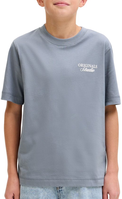 Close-up van een lichtblauwe t-shirt met witte, verhoogde tekst 'ORIGINALS Studio' op de borst.