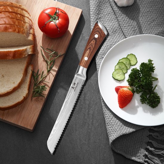 Couteau à pain japonais Damas, manche en bois, à côté de pain tranché, tomate et fraises sur une assiette.