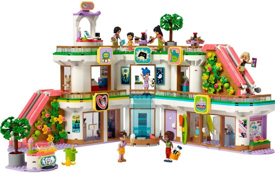 Centre commercial LEGO Friends avec mini-poupées, chariot à glaces, toboggans et plantes. Le bâtiment a plusieurs étages.