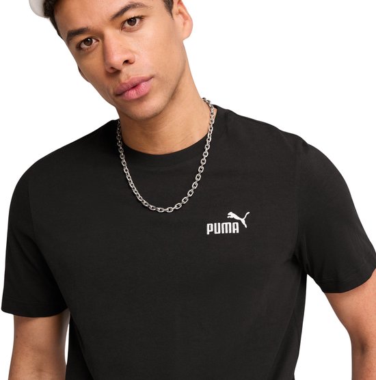 Man draagt zwart Puma T-shirt met klein wit Puma-logo en zilveren ketting.