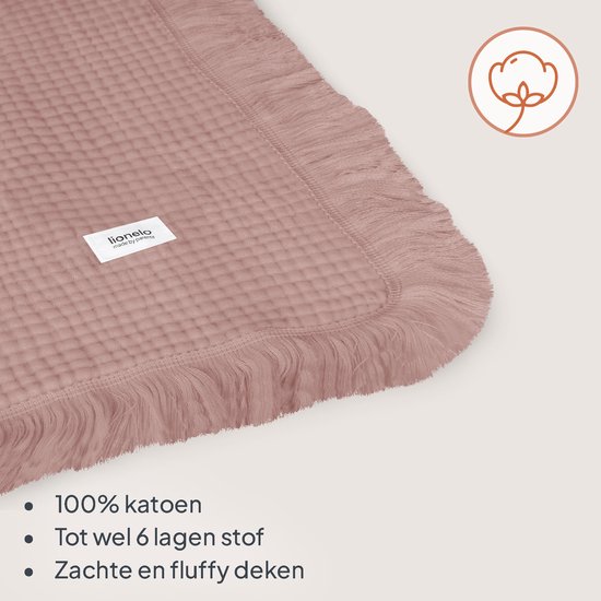 Lichtroze mousseline dekentje met wafelstructuur en decoratieve franjes aan de randen.