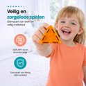 Lachend meisje houdt een oranje magnetische driehoek vast, gemaakt van BPA-vrij ABS-kunststof.