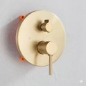 Gouden thermostatische mengkraan met twee hendels voor temperatuur en waterstroom.