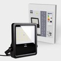 Zwarte LED-schijnwerper met verlichte voorkant, naast de productverpakking met energielabel.