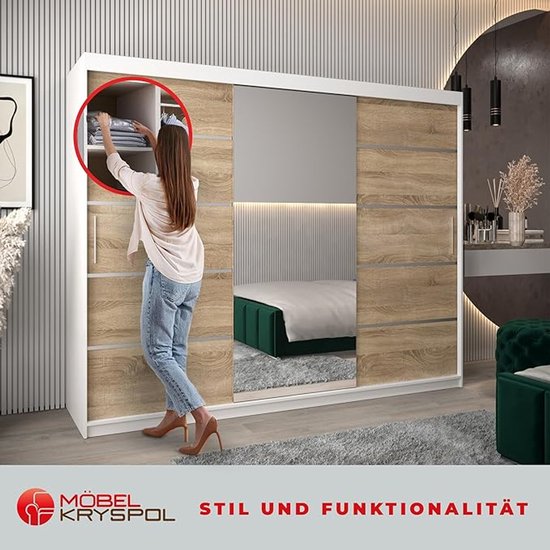 Vrouw legt kleding op een plank in een moderne kast met houtlook deuren en spiegel.