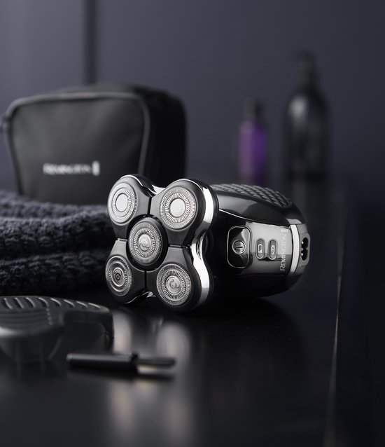 Zwart Remington hoofdscheerapparaat met accessoires, waaronder een tas en handdoek.