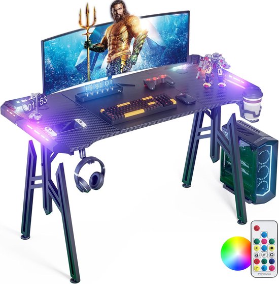 Zwart gamingbureau met Aquaman-achtergrond, muis, toetsenbord, controller en koptelefoon, met paarse en blauwe LED-verlichting.