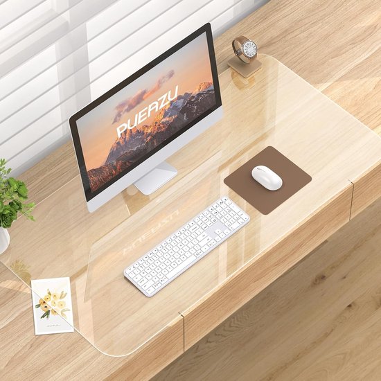 Un tapis de bureau transparent avec un ordinateur, un clavier et une souris sur un bureau en bois.