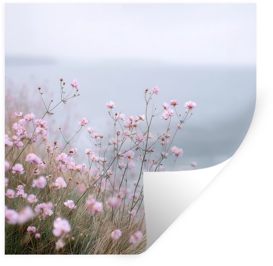 Fleurs roses fleurissent sur une côte rocheuse donnant sur la mer.