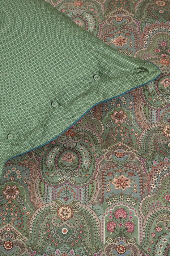 Detail van een groen dekbedovertrek met een paisley print met bloemen en blauwe bies.