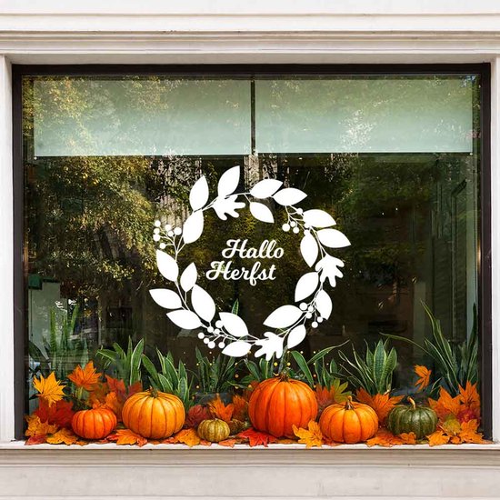 Sticker de fenêtre avec une couronne blanche de feuilles et de baies, avec le texte 'Hallo Herfst'. Autour de la couronne, il y a des citrouilles et des feuilles d'automne.