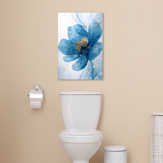 Peinture abstraite d'une fleur bleue avec des éclaboussures dorées, suspendue au-dessus de toilettes.