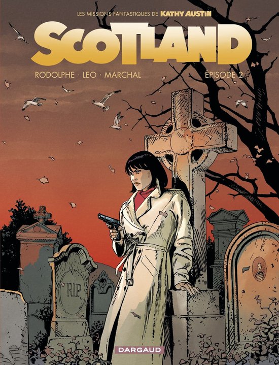 Stripboekcover: Kathy Austin in trenchcoat met een pistool op een kerkhof bij zonsondergang. Titel: SCOTLAND.