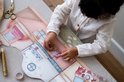 Meisje plakt stickers op een kartonnen speelset die een poppenhuis voorstelt.