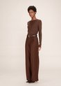 Mannequin en pantalon marron avec plis, ceinture et talons noirs.