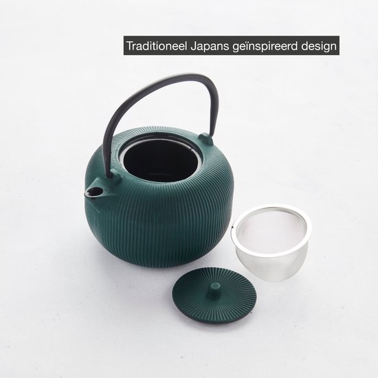 Donkergroene geribbelde gietijzeren theepot, open met een zilveren thee-ei en deksel ernaast.