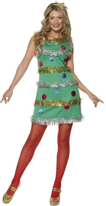 Model draagt groene jurk met kerstboomversiering, rode netpanty en gouden schoenen.