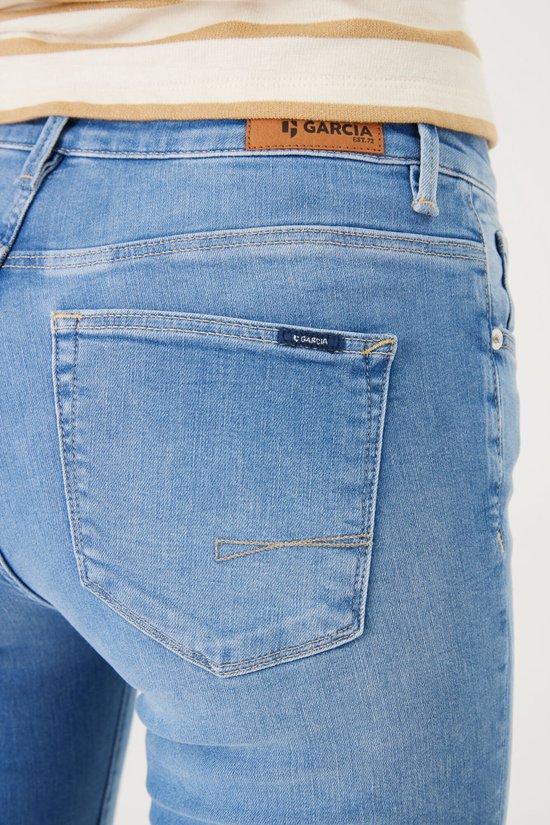 Achterkant van Garcia flared jeans in blauw denim met een bruin logolabel en GARCIA op de zak.