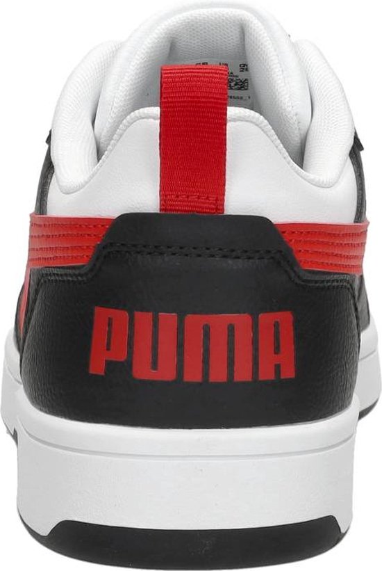 Achterkant van wit-zwart-rode PUMA sneaker met rood PUMA-logo en hiellus.