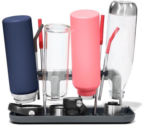 Égouttoir avec une bouteille bleu marine, en verre et rose, plus une bouteille transparente, sur un plateau gris foncé.