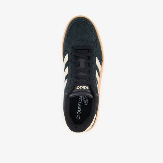 Bovenkant van een zwarte Adidas sneaker met gouden strepen, gummi zool en logo.