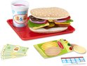 Een speeltje hamburger op een rood dienblad met frietjes, speelgeld en een drankje.