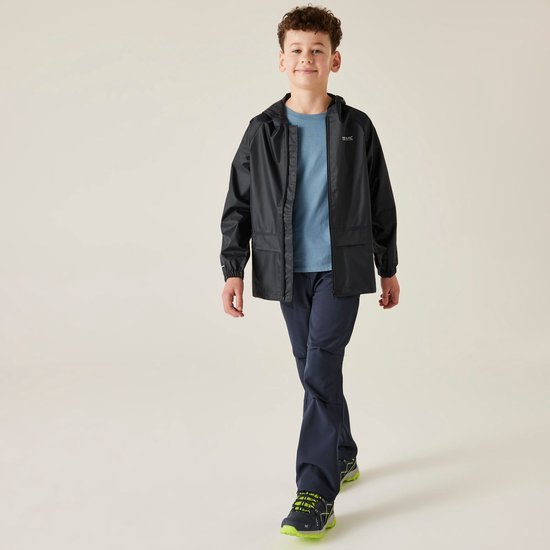 Jongen met krullend haar loopt in een donkergrijs, waterdicht jack met capuchon.