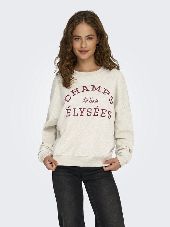 Model draagt een lichtgrijze sweater met geborduurde tekst 'CHAMPS Paris ÉLYSÉES' in donkerrood.