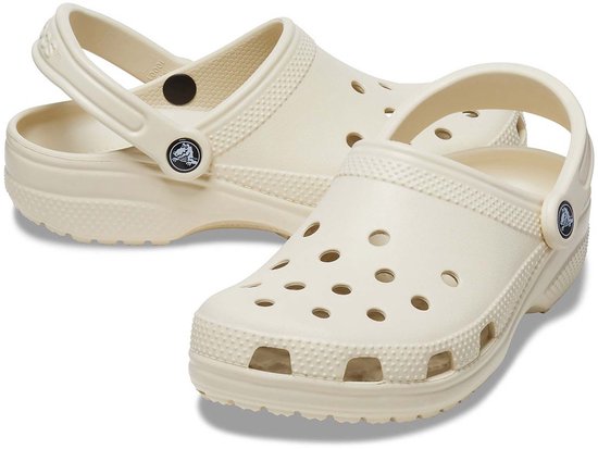 Paar lichtgele Crocs Classic klompen, met draagband, perforaties en textuurdetails.