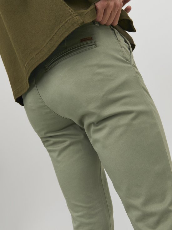 Detail van de achterkant van de olijfgroene chino broek met label.