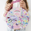 Un coffret créatif décoré de licornes, d'arcs-en-ciel et d'étoiles, avec des articles de loisirs créatifs dessus.