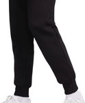 Onderkant van zwarte joggingbroek met witte sneakers en witte sokken.