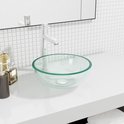 Lavabo ovale en verre vert clair avec un bord transparent, posé sur un comptoir blanc.