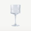 Een hoog cocktailglas met een brede voet, verticale ribbels en een diamantpatroon op de voet.