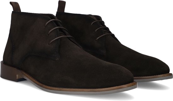Paar donkerbruine suède veterschoenen met een klassieke desertboot-stijl en bruine hak.