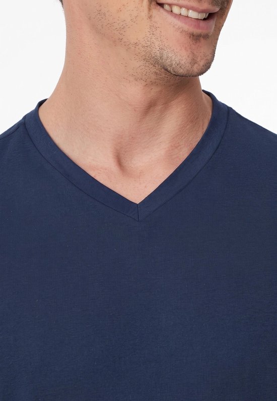 Close-up van de donkerblauwe pyjamatop met V-hals bij een man.