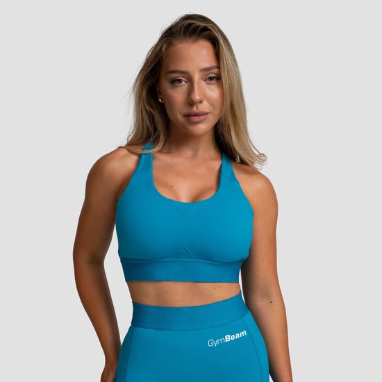 Vrouw draagt een aquamarijnblauwe GymBeam sportbeha met racerback-ontwerp.