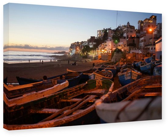 Une toile d'un village côtier méditerranéen pittoresque au coucher du soleil, avec des rangées de bateaux sur la plage.