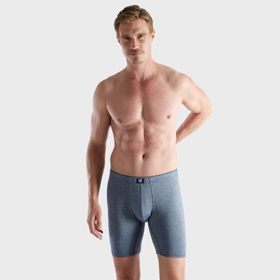 Man staand in blauw-wit gestreepte Ceceba boxershort, met het logolabel zichtbaar op de tailleband.