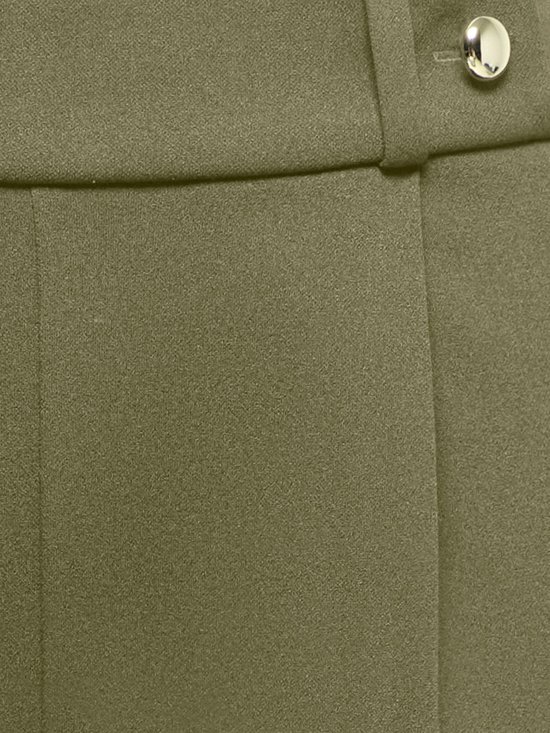 Zeer gedetailleerde close-up van een olijfgroene broek met zilveren knoopdetail op de tailleband.