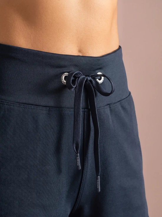 Close-up van elastische tailleband met donkerblauw koord en Sjeng Sports-uiteinden.
