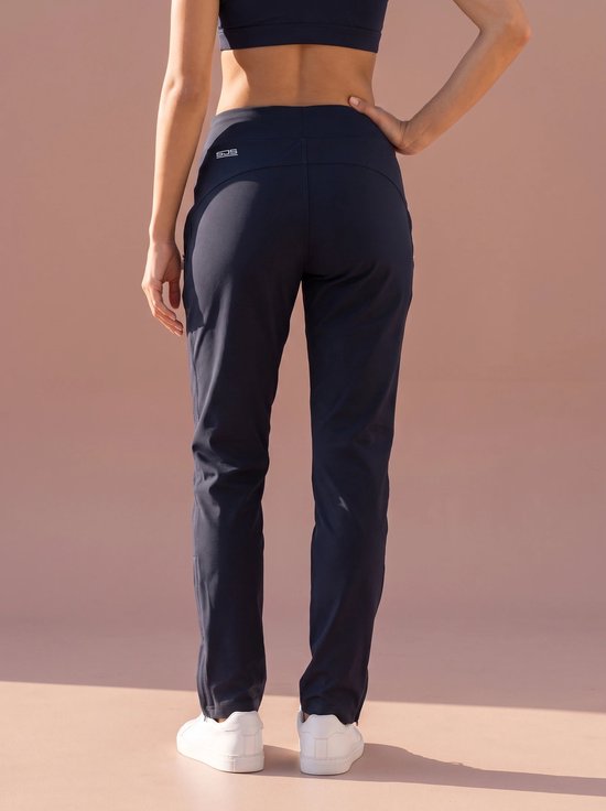 Achteraanzicht van donkerblauwe sportbroek met Sjeng Sports-logo op de tailleband.