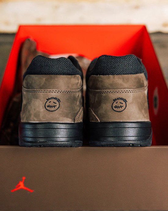 Achterkant van Jordan Jumpman Jack TR schoenen, bruin suède met Jack's gezicht, zwart contrefort en zwarte zool.